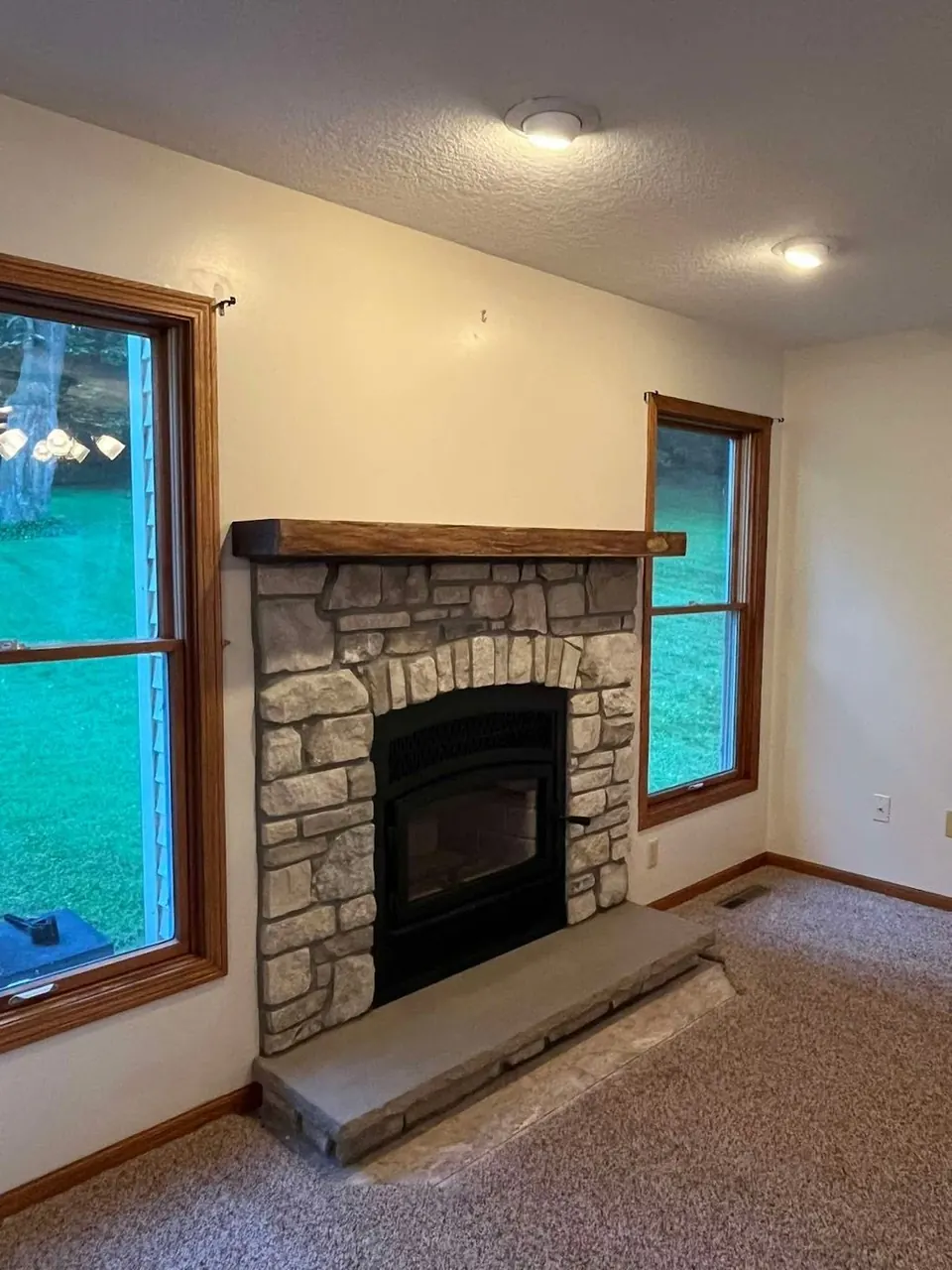 Stone fireplace with timber mantel in a home
